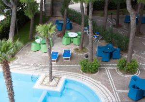 a resort with a pool and tables and chairs at Hotel Sporting in San Benedetto del Tronto