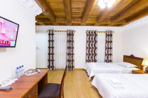 a hotel room with two beds and a tv at Hotel Volida Boutique in Bukhara
