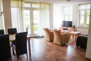 - un salon avec une table, des chaises et une télévision dans l'établissement Residence Aan de Kust, à Noordwijk aan Zee