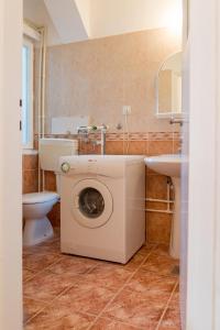 ein Badezimmer mit einer Waschmaschine und einem Waschbecken in der Unterkunft Apartman Andjela in Tivat
