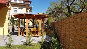 a wooden gazebo in the backyard of a house at Poroszlay Apartman in Debrecen