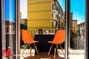 une table avec des chaises orange devant une fenêtre dans l'établissement Montedonzelli B&B, à Naples