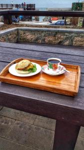 a wooden tray with a sandwich and a cup of coffee at Jin Sha Ting Hai Homestay I in Nangan
