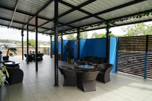 un patio con sillas, mesas y una pared azul en Mariners on the Waterfront, en Batemans Bay