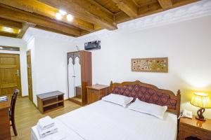 1 dormitorio con 1 cama blanca grande y escritorio en Hotel Volida Boutique, en Bukhara
