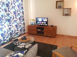 ein Wohnzimmer mit Sofa und Fernseher in der Unterkunft Apartment Vistamar 2 in Cumbre del Sol