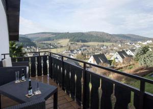 un balcón con una mesa con copas de vino. en Rosalie - Lake - Hiking&Swimming - Cozy&Nature, en Winterberg