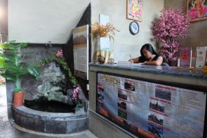 a woman sitting at the counter of a restaurant at Ubud Sensasi Bungalow in Ubud