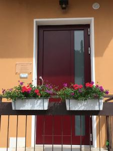 uma porta com caixas de flores numa varanda em Appartamenti Francesco em Peschiera del Garda