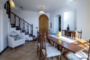 uma sala de jantar com uma mesa de madeira e cadeiras em Casa Rossa em Ravello