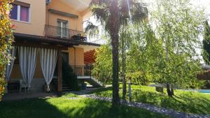 a house with a palm tree in the yard at Appartamenti Villacedro in Lazise