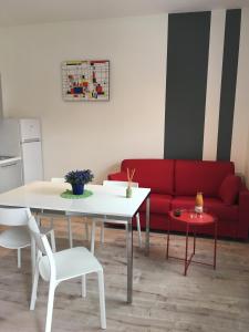 uma sala de estar com uma mesa e um sofá vermelho em Appartamenti Francesco em Peschiera del Garda