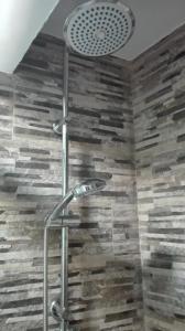 a shower in a bathroom with a stone wall at Hotel Rural Casa Indie in Rabanal del Camino