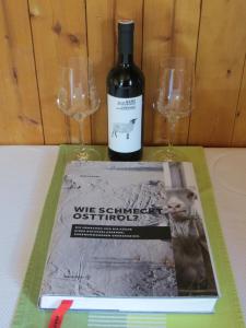 butelka wina i dwa kieliszki do wina na stole w obiekcie Walcheggerhof w mieście Innervillgraten