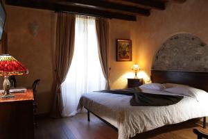 a bedroom with a bed and a large window at Agriturismo Villa Bissiniga in Salò