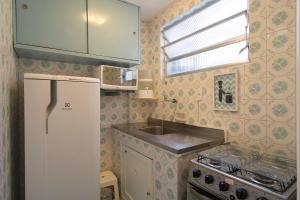 a small kitchen with a refrigerator and a sink at Flat 407 in Petrópolis