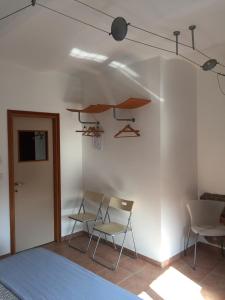 a room with two chairs and a white wall at Vicolo del Pozzo in Barolo