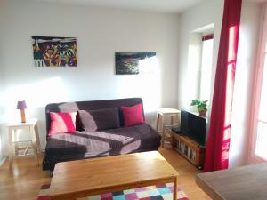 een woonkamer met een bank en een tv bij L'Orée de Versailles in Versailles