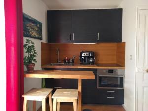 een keuken met een houten tafel en een aanrechtblad bij L'Orée de Versailles in Versailles