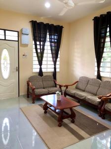 a living room with two couches and a coffee table at Twin Homestay A in Kuala Terengganu