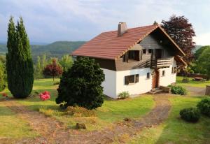 ein kleines Haus auf einem Feld mit Bäumen in der Unterkunft Chalet Beau Regard in Hellert