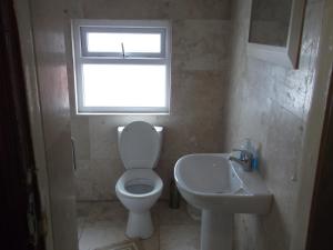 a bathroom with a toilet and a sink and a window at Durham house hotel in Gateshead