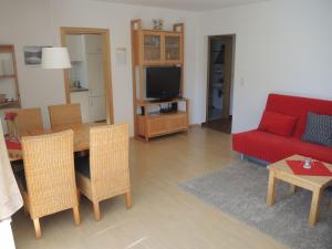 sala de estar con mesa y sofá rojo en Ferienwohnung Rösner, en Herzhausen