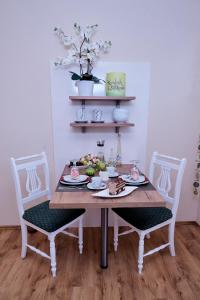 una mesa con un plato de comida con dos sillas en Hörnlestubn en Bad Kohlgrub