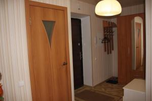 a bathroom with a wooden door and a mirror at Apartment on Gagarina in Smolensk