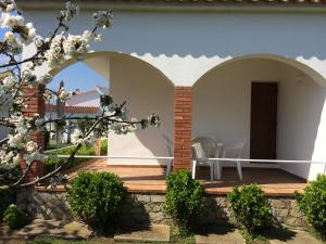 een patio met een stoel op een houten terras bij Villa Montserrat 1, Terrace & Pool in Sant Martí d’Empúries