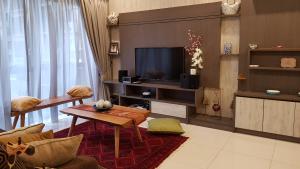 ein Wohnzimmer mit einem TV und einem Sofa in der Unterkunft Suite Deluxe at Icon City in Petaling Jaya