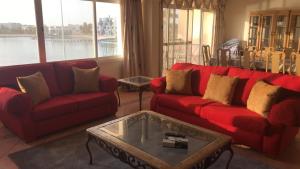 a living room with red couches and a coffee table at Durat Alarous Apartment in Durat Alarous