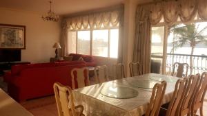 a living room with a table and a red couch at Durat Alarous Apartment in Durat Alarous