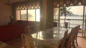 a dining room table and chairs with a view of the water at Durat Alarous Apartment in Durat Alarous