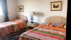 a room with two beds and a lamp in it at Durat Alarous Apartment in Durat Alarous