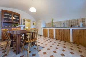 uma grande cozinha com uma mesa de madeira e cadeiras em Mimma holiday house em Modica