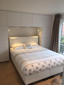 a white bed in a bedroom with a window at l'Intervalle in Mont-Saint-Guibert