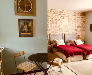 a bedroom with two beds and a table in it at Le trente trois in Uzès