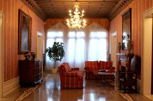 un soggiorno con sedie rosse e un lampadario a braccio di Ca' Nigra Lagoon Resort a Venezia