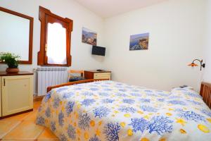 - une chambre avec un lit et une couette bleue et blanche dans l'établissement La Maison de Titty & Margherita, à Piano di Sorrento