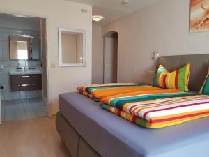 a bedroom with a bed with a colorful blanket on it at Gästehaus Rana in Rust