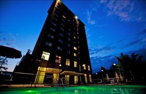 a tall building with a green pool in front of it at Novotel Torino Corso Giulio Cesare in Turin