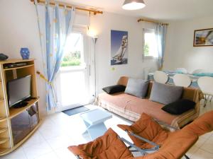 a living room with a couch and a tv at Villa Anna in Sarzeau