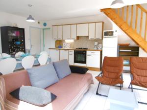 - un salon et une cuisine avec un canapé et des chaises dans l'établissement Villa Anna, à Sarzeau