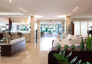 a living room with white couches and a dining room at Hotel Bauer & Sporting in Lido di Jesolo