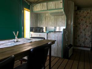 y cocina con mesa de madera, sillas y fogones. en Recreational Farm Camping de Kreitsberg, en Zelanda