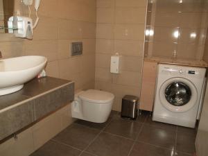 a bathroom with a toilet and a sink and a washing machine at Brigitte house in Chania Town +24 photos