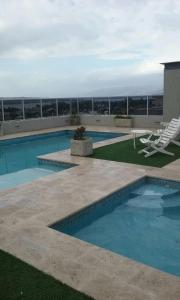 a swimming pool with a lounge chair and avisor at Opera Villa Carlos Paz in Villa Carlos Paz