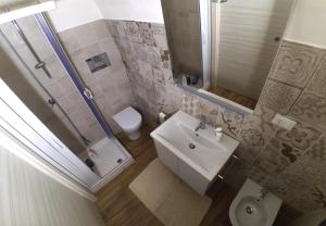 a bathroom with a sink and a shower and a toilet at Casetta Maremè in San Vito lo Capo
