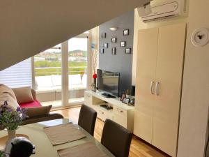 Una sala de estar con una mesa y un televisor. en Sun&Sea Apartment, en Vodice
